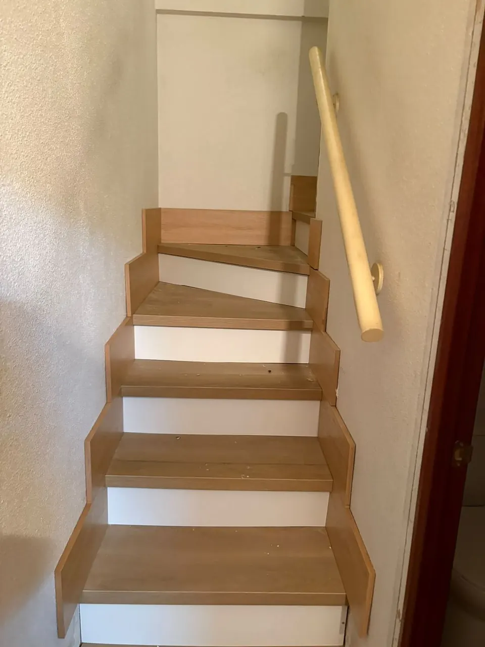 Escalera estrecha forrada en madera